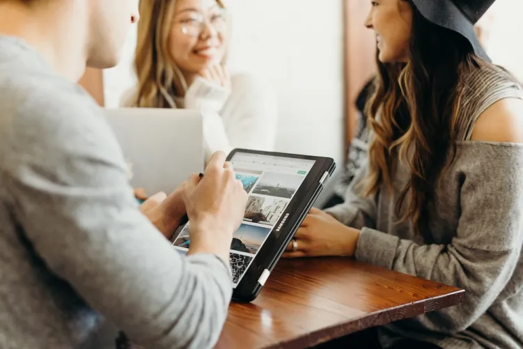 3 people talking and looking at tablet