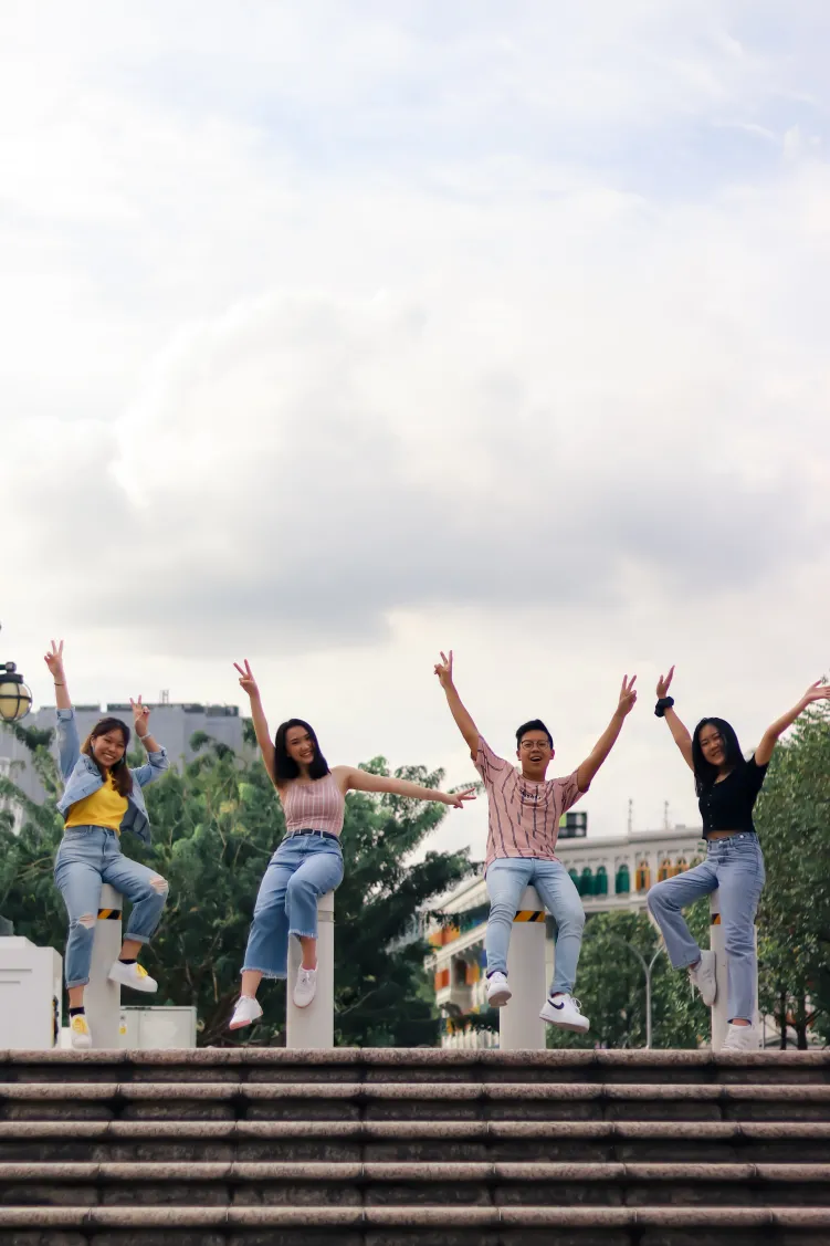 4 people with hands in air