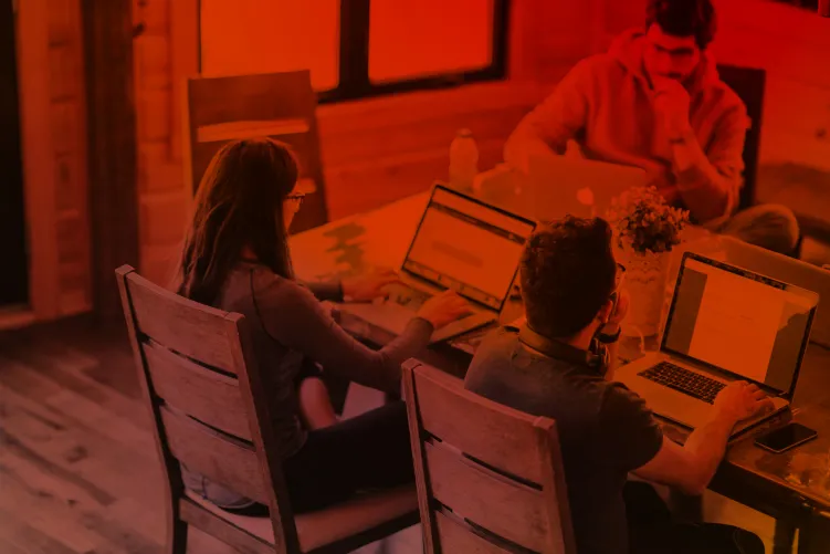 People sat around a table on laptops