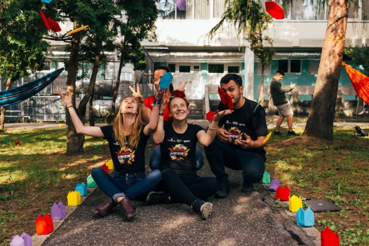 People sat down throwing paper in the air