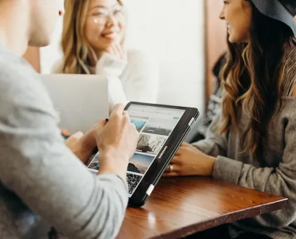 3 people talking and looking at tablet