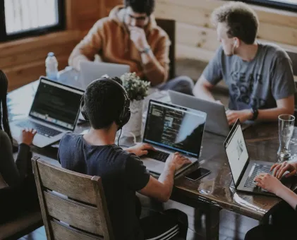 People on laptops around a table