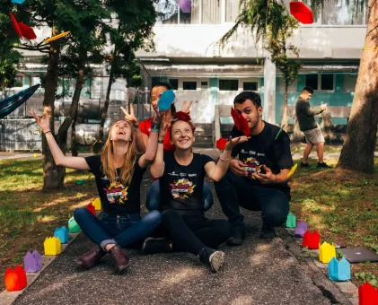 People sat down throwing paper in the air